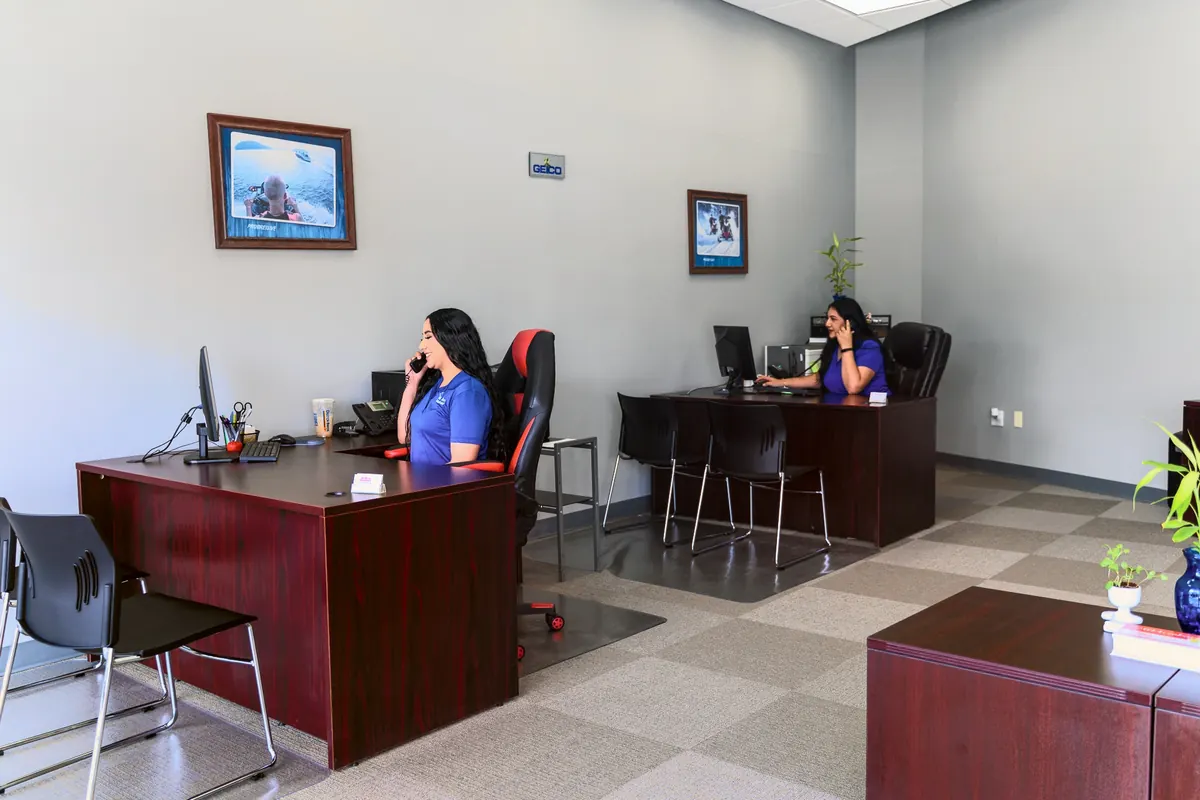 Inside the office: two desks, with team members on the phone