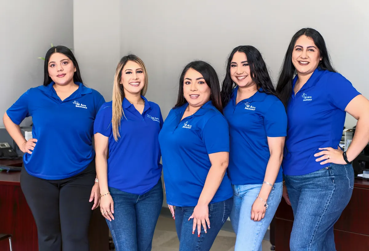 The five team members in blue shirts inside the office